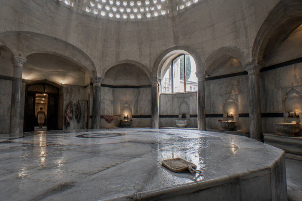 Warm marble göbektaşı platform inside a historic Turkish bath under a perforated dome