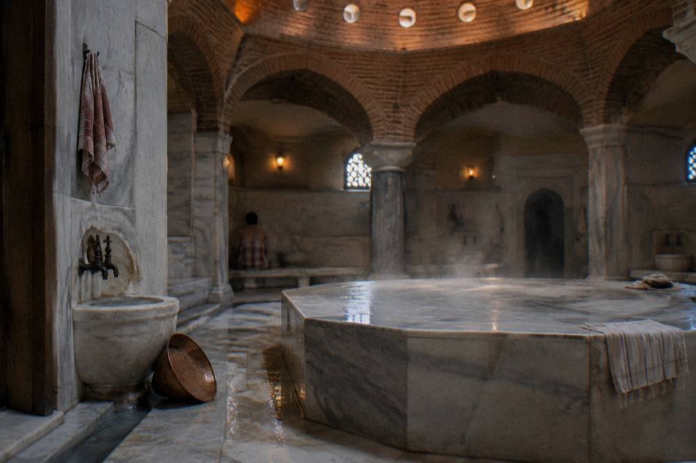 Steam rising over the heated marble platform inside a traditional Turkish bath hall