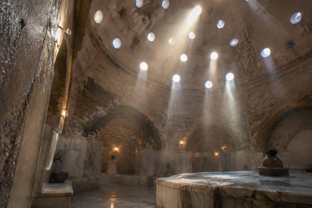 Domed hamam ceiling with small star-shaped glass openings letting in shafts of light