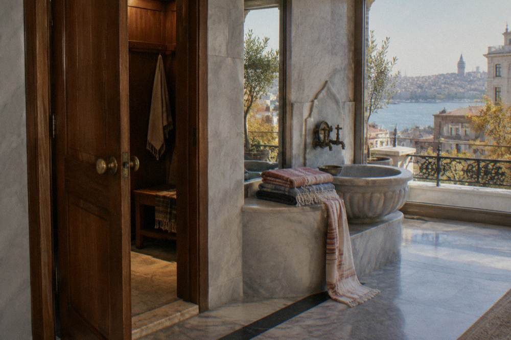 Wooden changing cabin and peştemal cloths folded beside a marble wash basin in a Turkish bath
