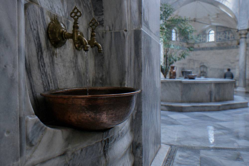 Copper basin and brass taps set into a marble hamam wall niche
