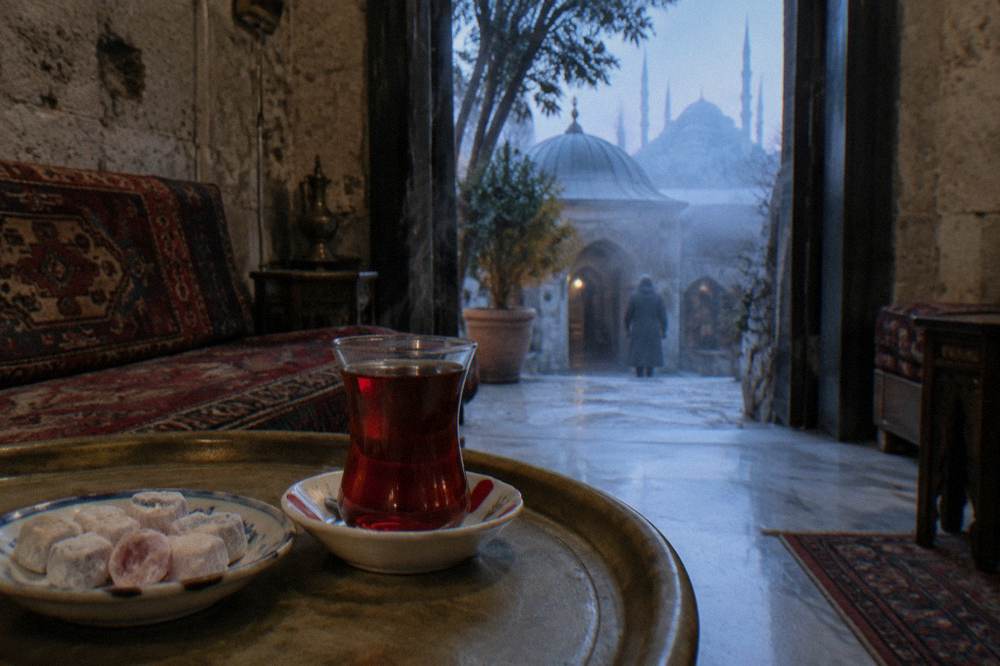 A glass of Turkish tea and a plate of Turkish delight on a tray in a hamam rest lounge.