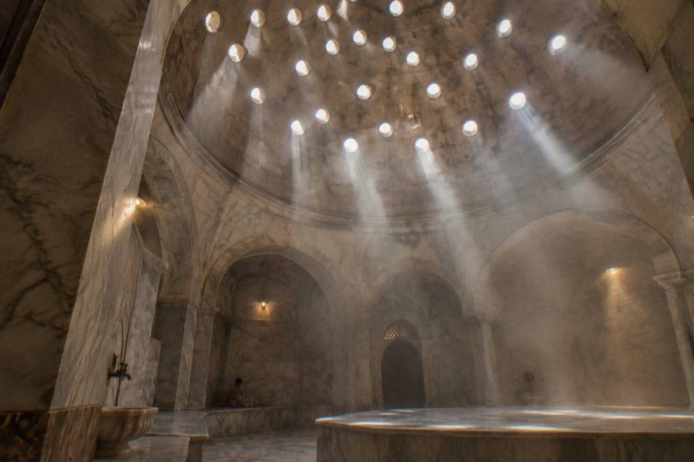 Ottoman bath dome pierced with small round glass circles casting beams of light