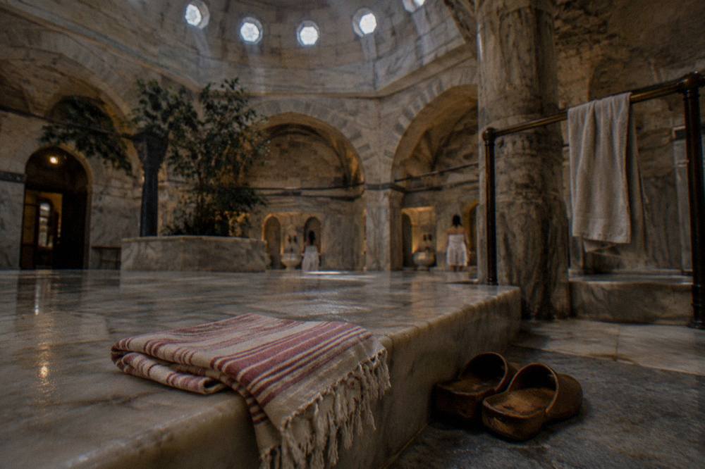 Warm marble platform beneath a domed ceiling inside a historic Istanbul hamam