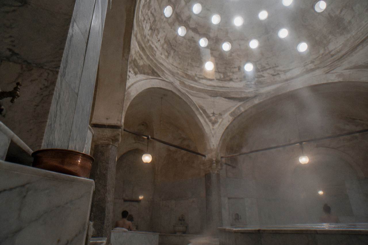 Domed ceiling of a historic hamam in Istanbul pierced with small round glass lights