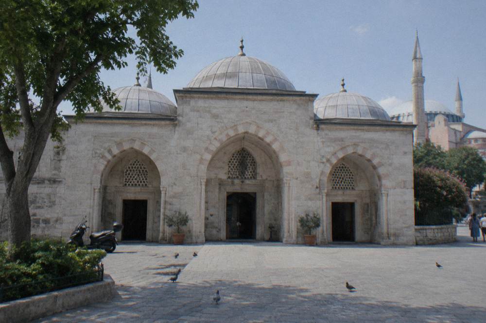 Symmetrical stone facade of a historic bathhouse with matching arched entrances