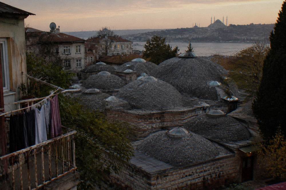 Pebbled hamam domes seen from above with glass eye lights piercing the roof