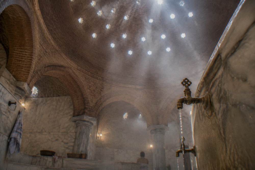 Ottoman bath dome with small star-shaped glass openings casting light through steam