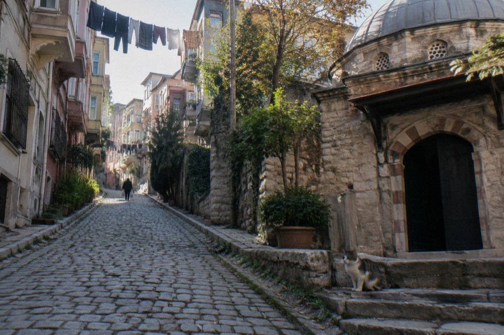 Steep cobblestone street in Beyoglu with old apartment facades and hanging laundry
