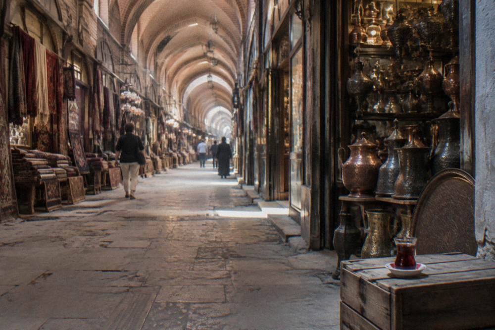 Covered lane of the Grand Bazaar with arched ceilings and shopfronts in warm light