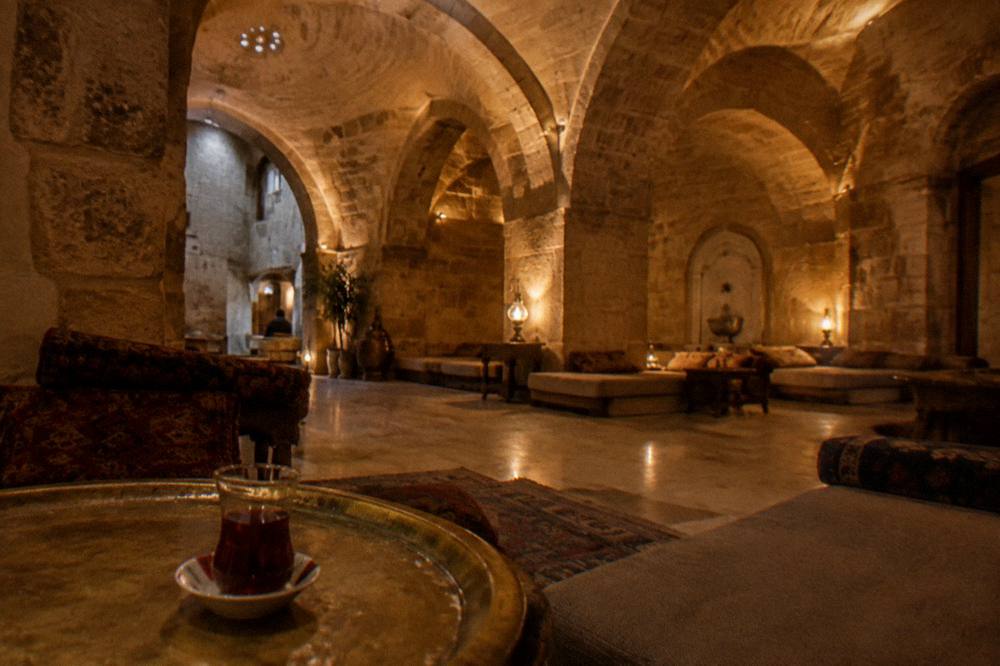 Warm lamplight on the stone arches of an empty hamam relaxation room