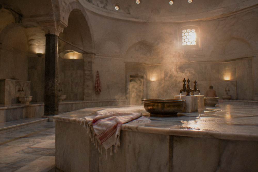 Wide domed hot room with a raised marble bathing platform and basin taps