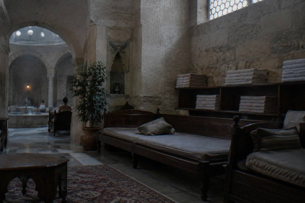 Wooden divans and folded towels along the relaxation lounge of an old hamam