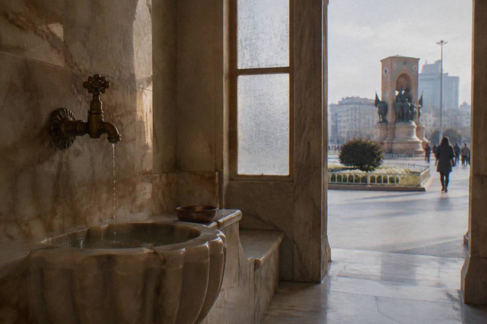 Warm marble interior of a private hammam room with a domed ceiling and a stone basin