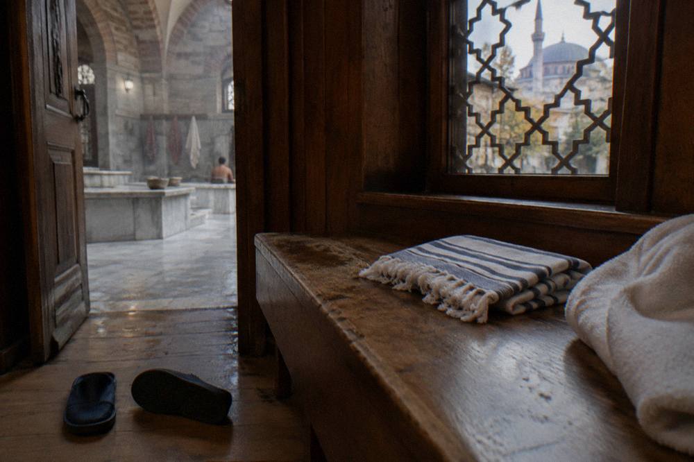 Wooden changing cabin with a folded striped peshtemal cloth, slippers and a towel on a bench